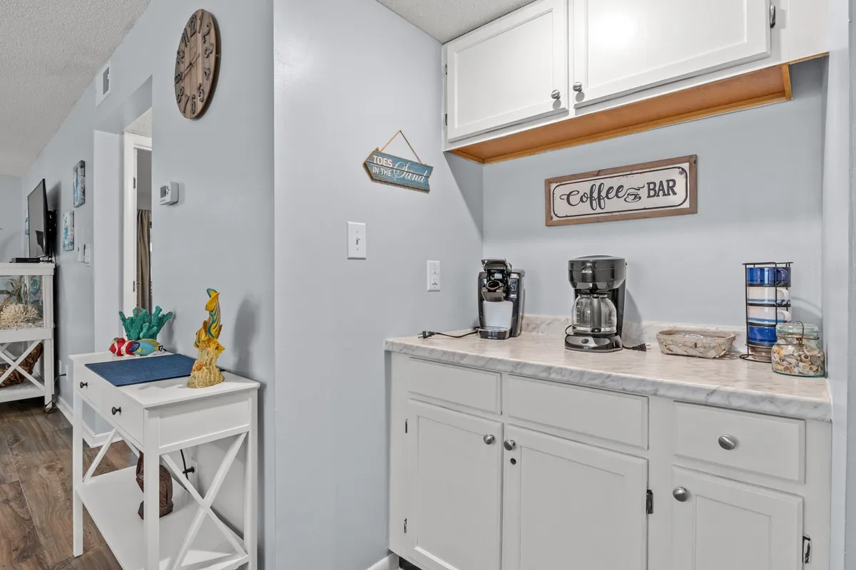 A cozy coffee station set against a welcoming interior features decorative items and a wall sign, suggesting a perfect spot to start the morning with coffee and a view.