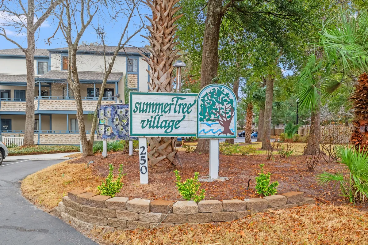 An inviting garden area with the 'summerTree village' signage, surrounded by palm trees and well-kept landscaping, suggesting a vibrant and friendly community atmosphere ideal for families and gatherings.