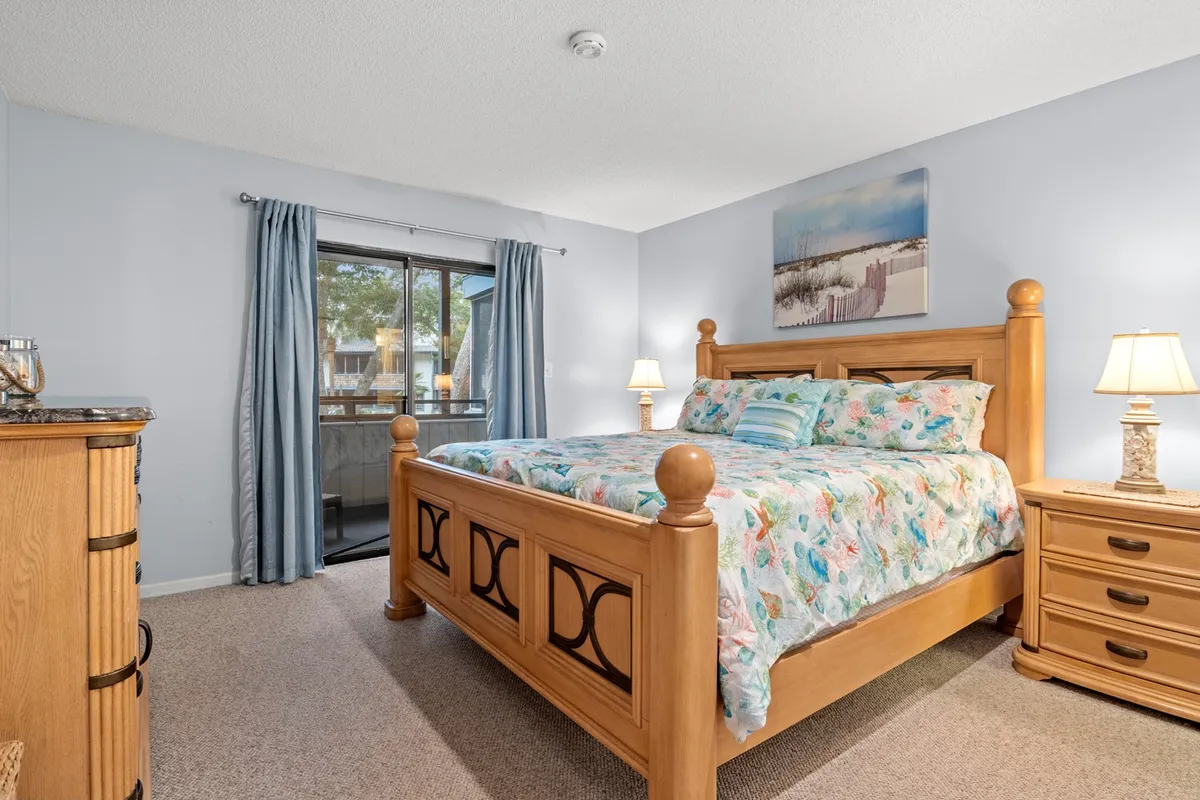 A spacious bedroom bathed in natural light, featuring a plush king bed, dressers for generous storage, a window with tranquil views, and tasteful artwork adorning the walls. The inviting layout suggests a perfect place for relaxation, reading, or winding down after a day of adventure.