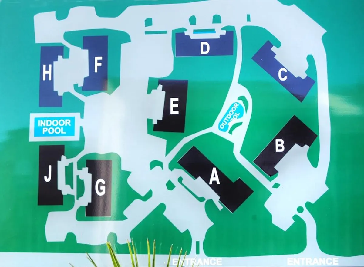 This image showcases both the indoor and outdoor pool areas, with the building's exterior visible in the background. The scene highlights spaces for swimming, lounging, and offers a sense of the property’s layout and communal amenities.